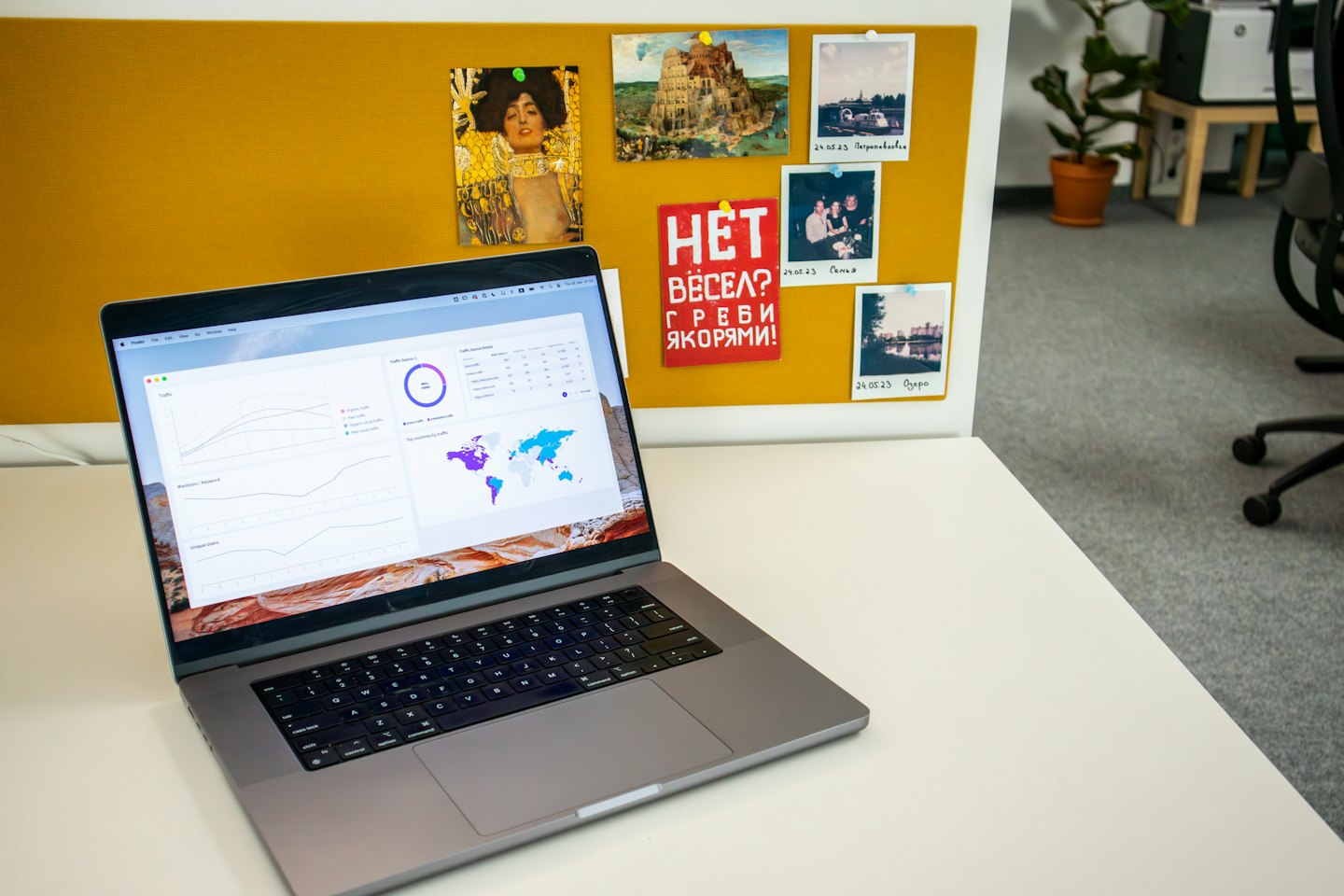 Srebrny laptop z panelem analityki danych na białym biurku.